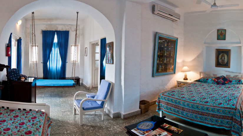 Hindola Mahal offers a spacious bed and an archway that leads to the living area - Hill Fort Kesroli Alwar Rajasthan