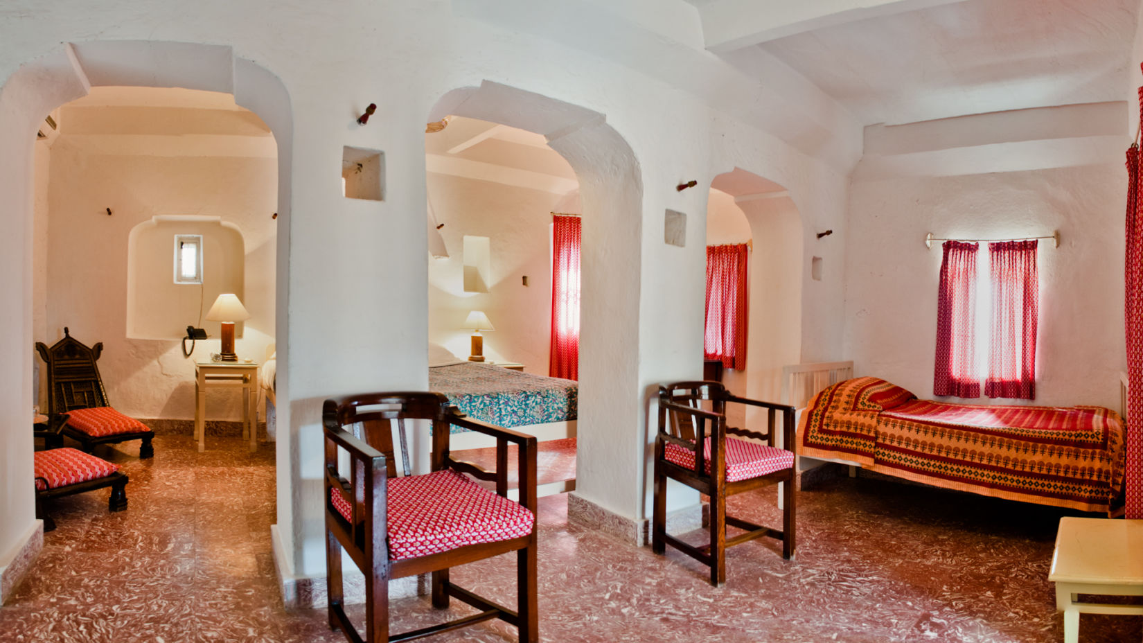 Hill Fort Kesroli 14th Century Alwar - interior view of the Nirmal Mahal with numerous seating options, and red decor