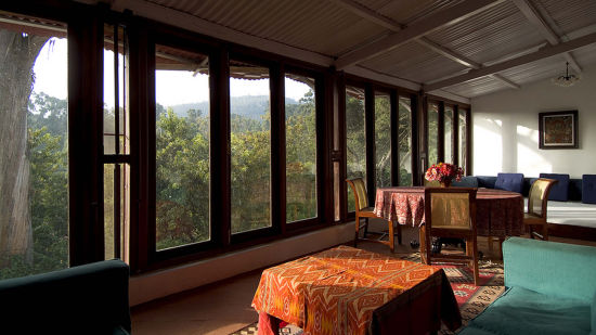 Floor to ceiling windows showing the greenery outside and tables set up inside - Wallwood Garden - 19th Century, Coonoor