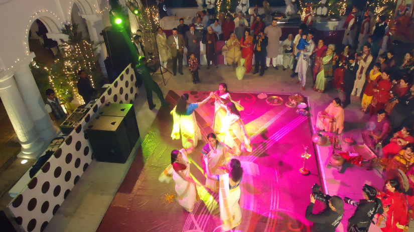 Women dancing with other people looking during a wedding celebration - The Baradari Palace