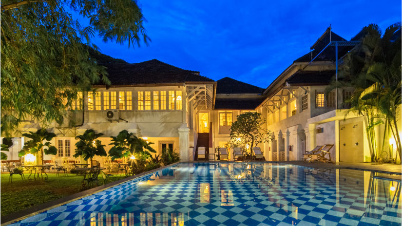 The Tower House - A chequered pool surrounded by bamboo trees and sunbeds on the right