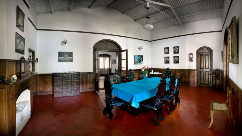 Side view of the large table with blue cloth covering and beautifully carved wooden chairs next to it - Wallwood Garden - 19th Century, Coonoor