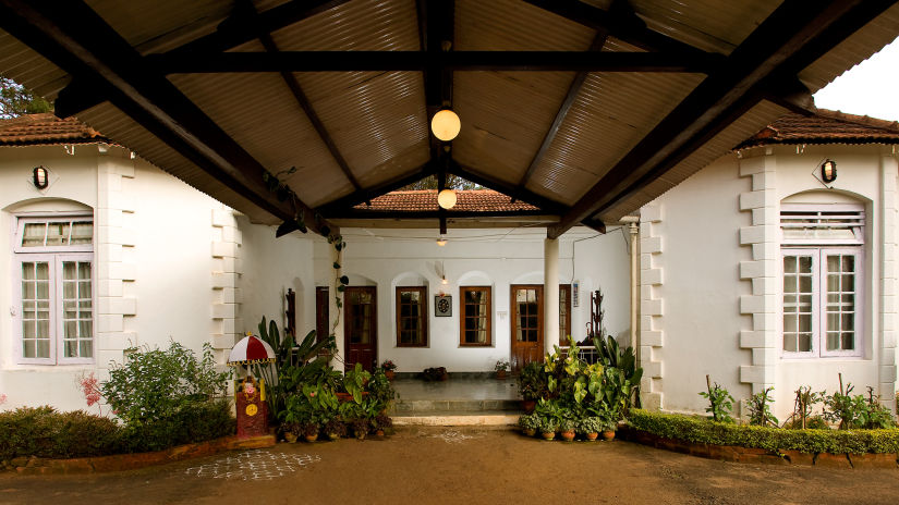 A closeup view of the entrance to the hotel with potted plants on either side - Wallwood Garden - 19th Century, Coonoor