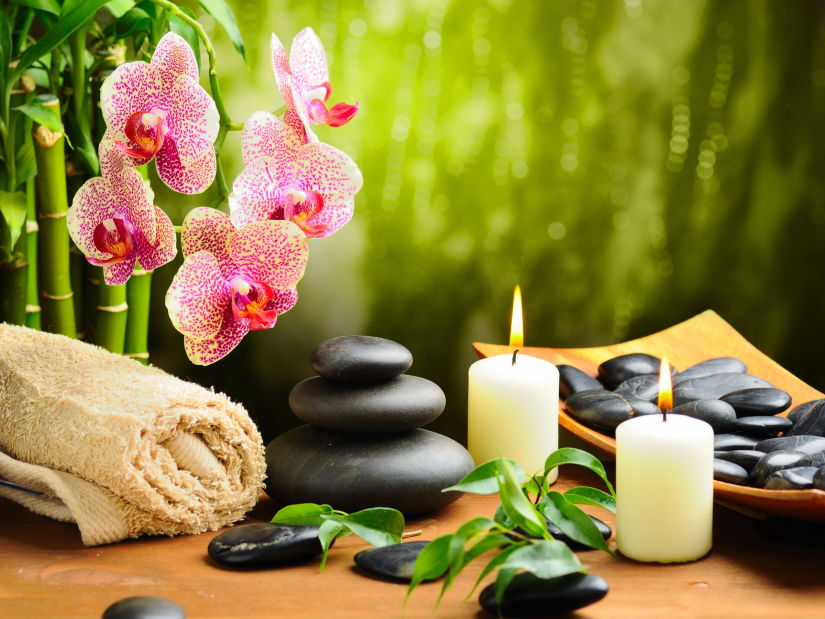 a candle, a flower and other healing objects kept in a spa