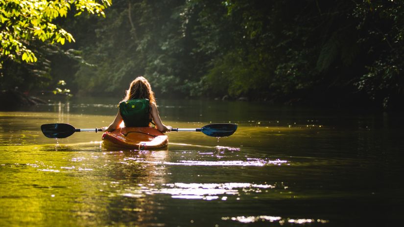 lady doing Kayaking in dense jungle