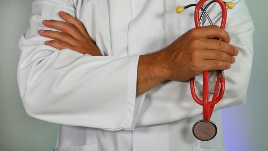 a man in a white coat holding a stethoscope