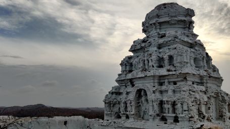 an image of a temple with carvings on the exterior however has been worn out with time and weather changes