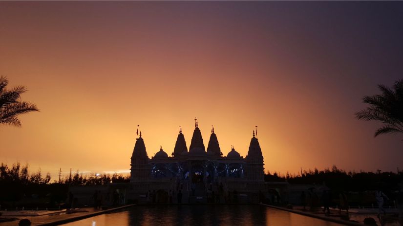 A silhouette of Surya Mandir with a serene sunset in the background