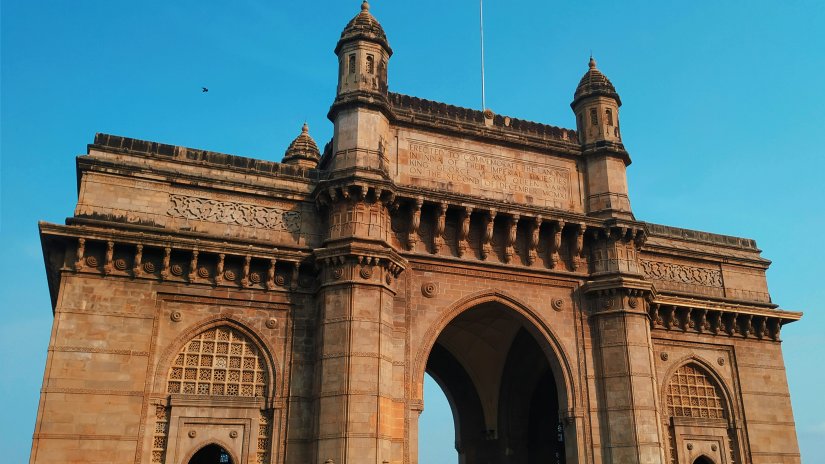 a close up image of the gateway of India with blue sky in the background
