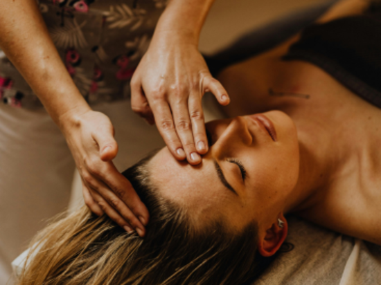 A woman receiving a forehead massage in a spa.