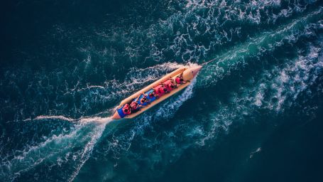 Top view of people enjoying Banana Boat Ride surrounded by deep waters