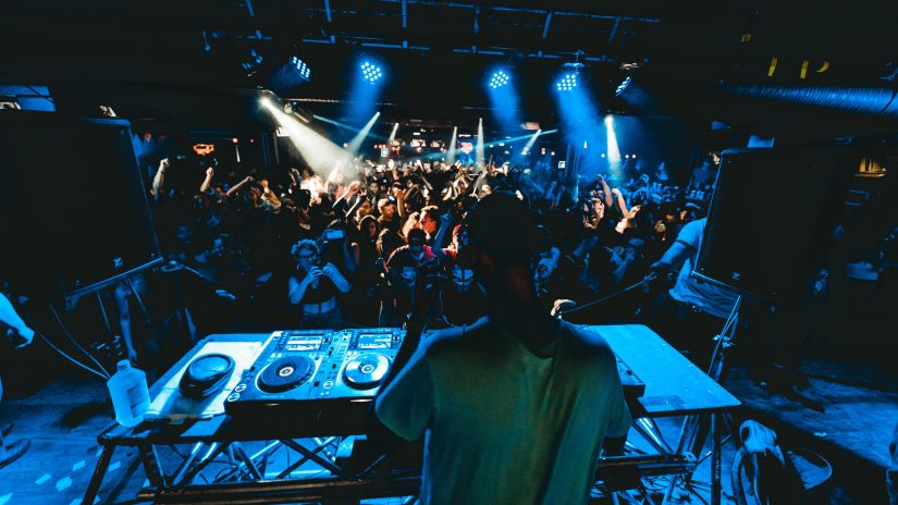 A DJ playing on stage in a club in North Goa