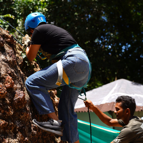 Person scaling a rock wall during wall climbing - Stone Wood Nature Resort, Gokarna