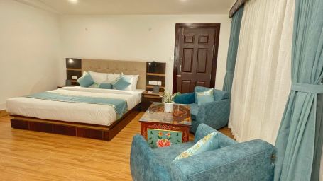 Premium Room bedroom with sofas and table - Voyage Glenz Resort