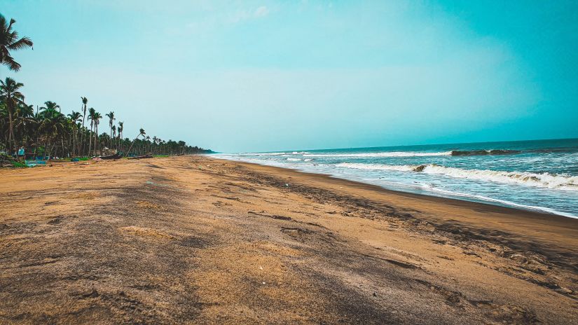 A long shot beach where waves are hitting the shore.