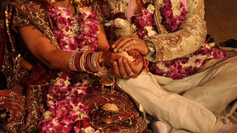 a bride and groom holding hands at VITS Luxury Business Hotel Aurangabad