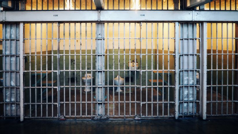 an image of a prison with walls behind iron bars