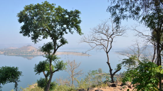 view of a lake surrounded by greenery and hillocks