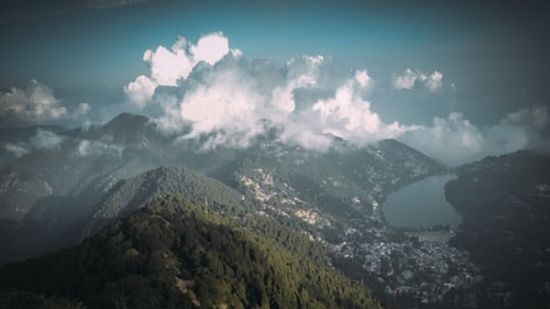 forest covered mountain with white clouds