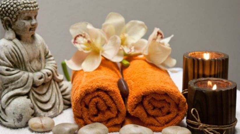 a small statue, towels and candles kept on a table at the spa