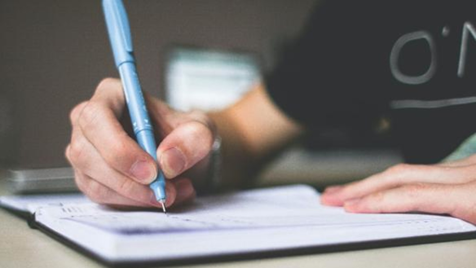 A person writing on a piece of paper