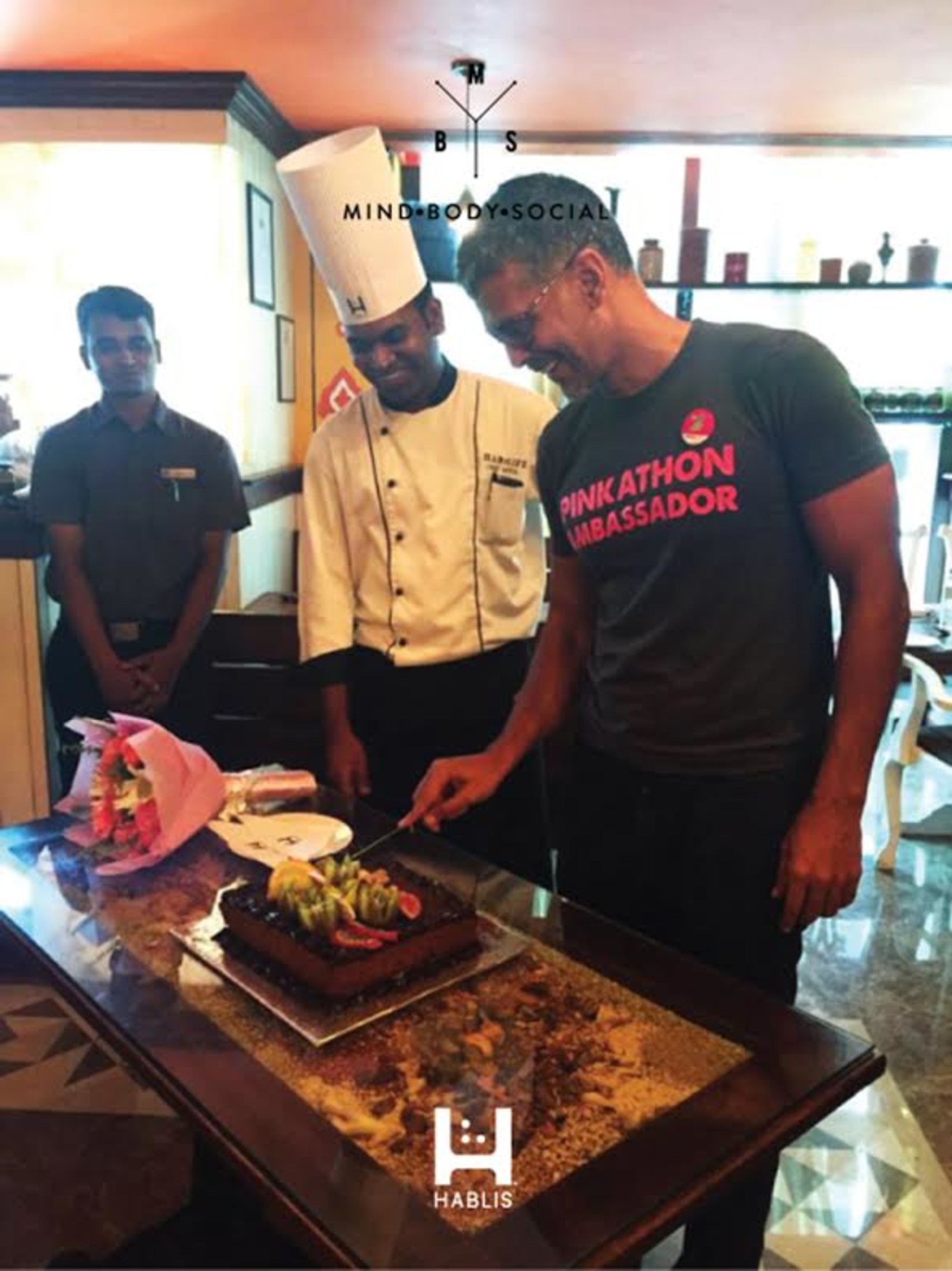 Milind Soman with a chef cutting a cake at Hablis Hotel, Chennai