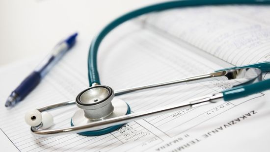 Stethoscope and pen laid on a register