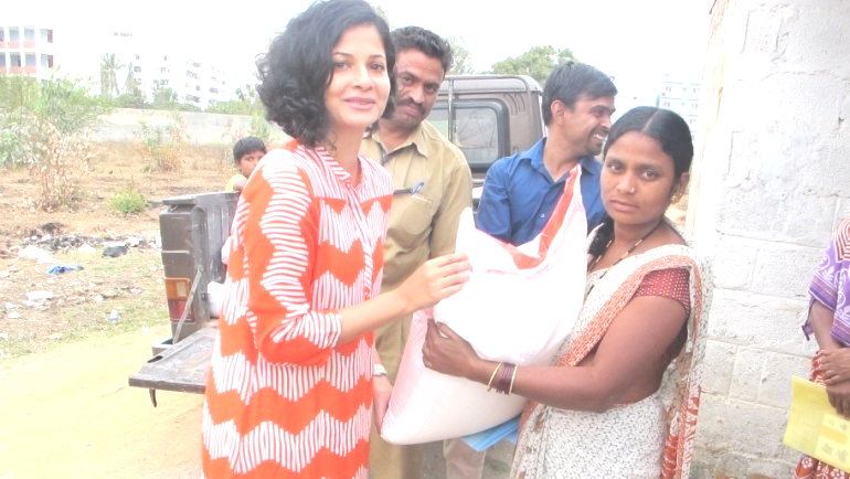 Lady giting a bag of grocery to another lady