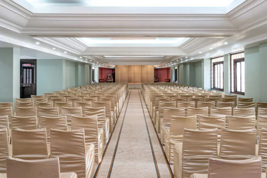 alt-text Back view of Banquet Hall with multiple chairs and modern interior - Hotel Ram International, Pondicherry