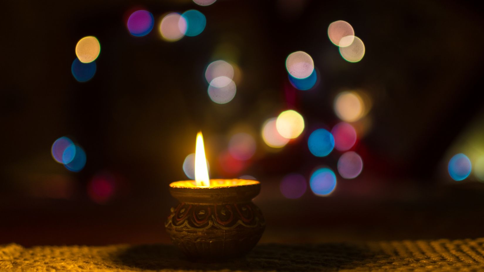 Diya with lights in the background