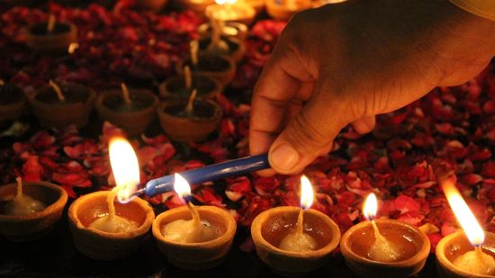 a person lighting diyas