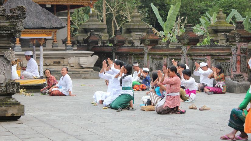 A group of people sitting with folded hands and offering prayers