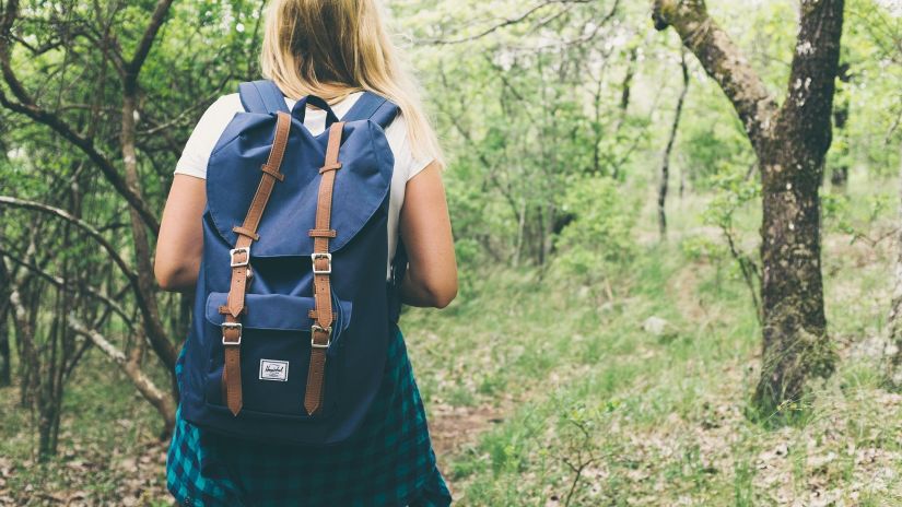 a girl with a backpack going for a trek