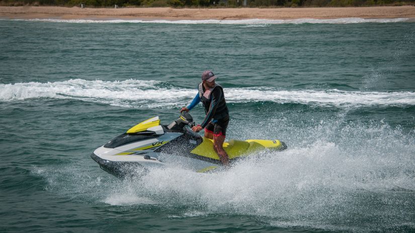 Person jet skiing and cutting through waters