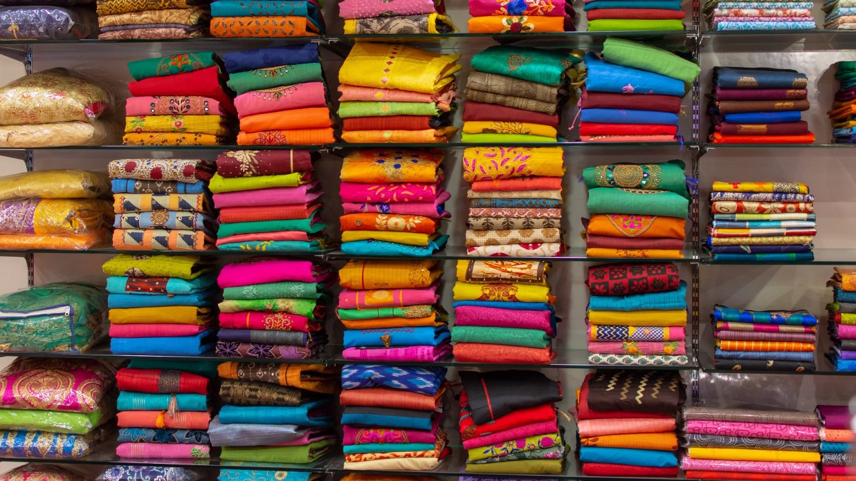 stacks of sarees at a shop