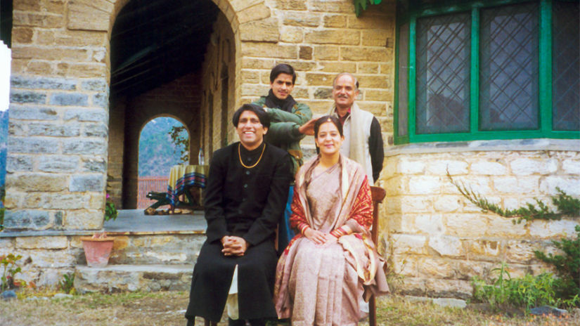 The Ramgarh Bungalows - a couple after their Kumaon Wedding in front of Old Bungalow with family members behind them