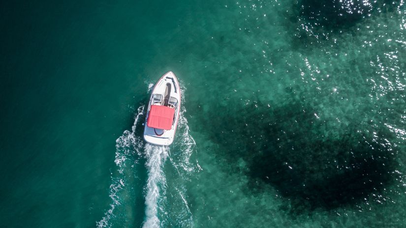 aerial shot of motorboat moving forward sea