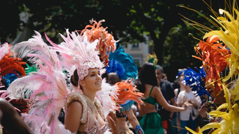 A women in pink carnival clothes grooving on the streets along with our similarly dressed women captured during the day