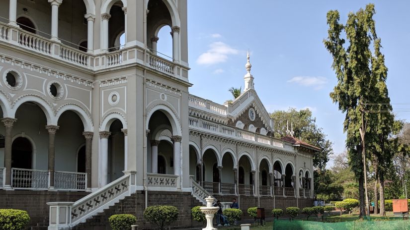 An image of Aga Khan Palace capturing the lush gardens and intricately designed building -Fort JadhavGADH 