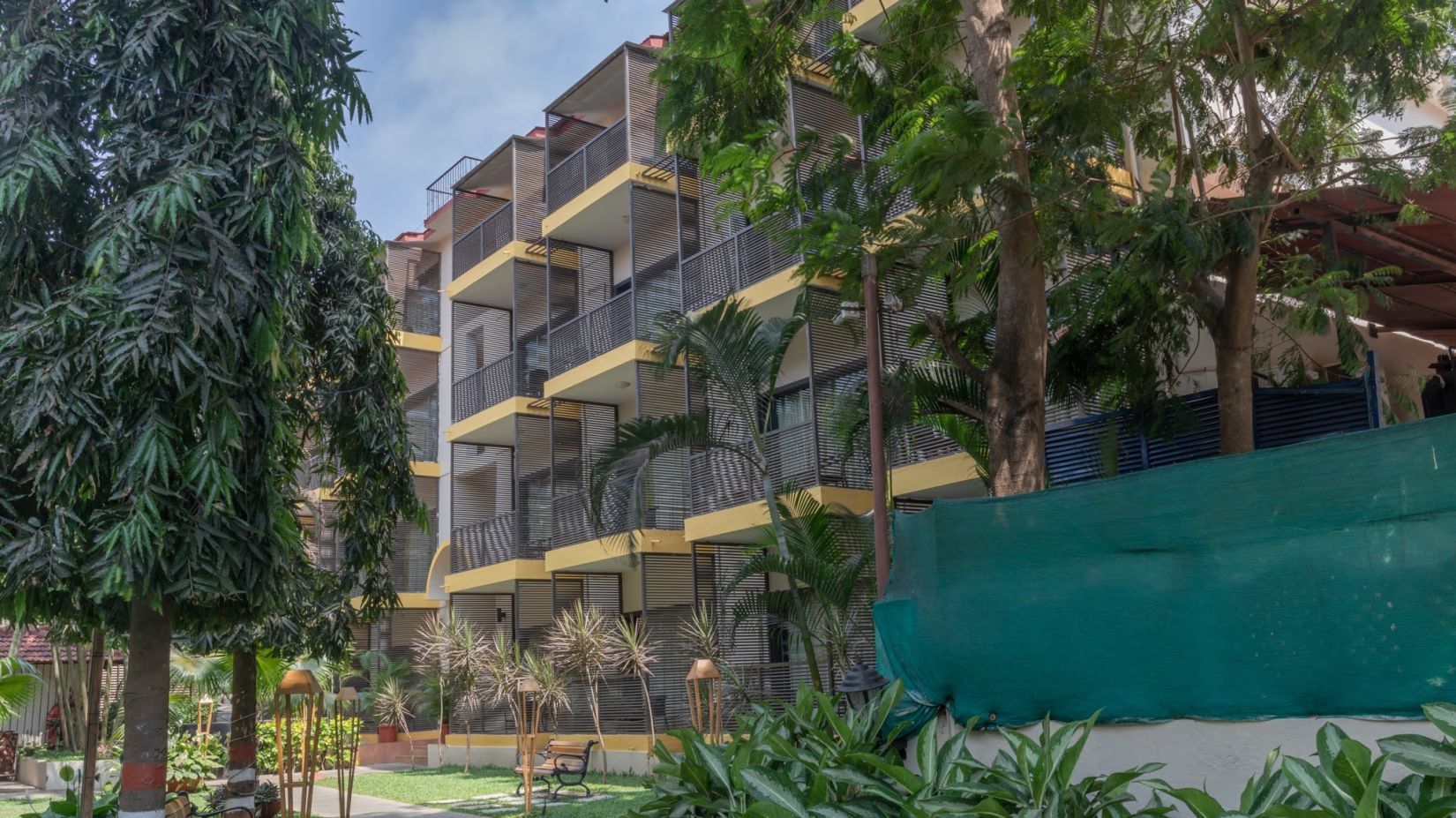 View of the building facade surrounded by trees at Kyriad Prestige Calangute, Goa 