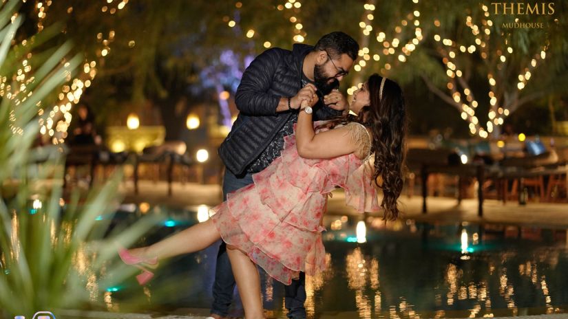 a couple posing in a dancing position with decorations in the background