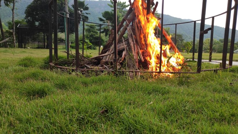 bonfire inside a metal cage with grass surrounding it - Black Thunder, Coimbatore