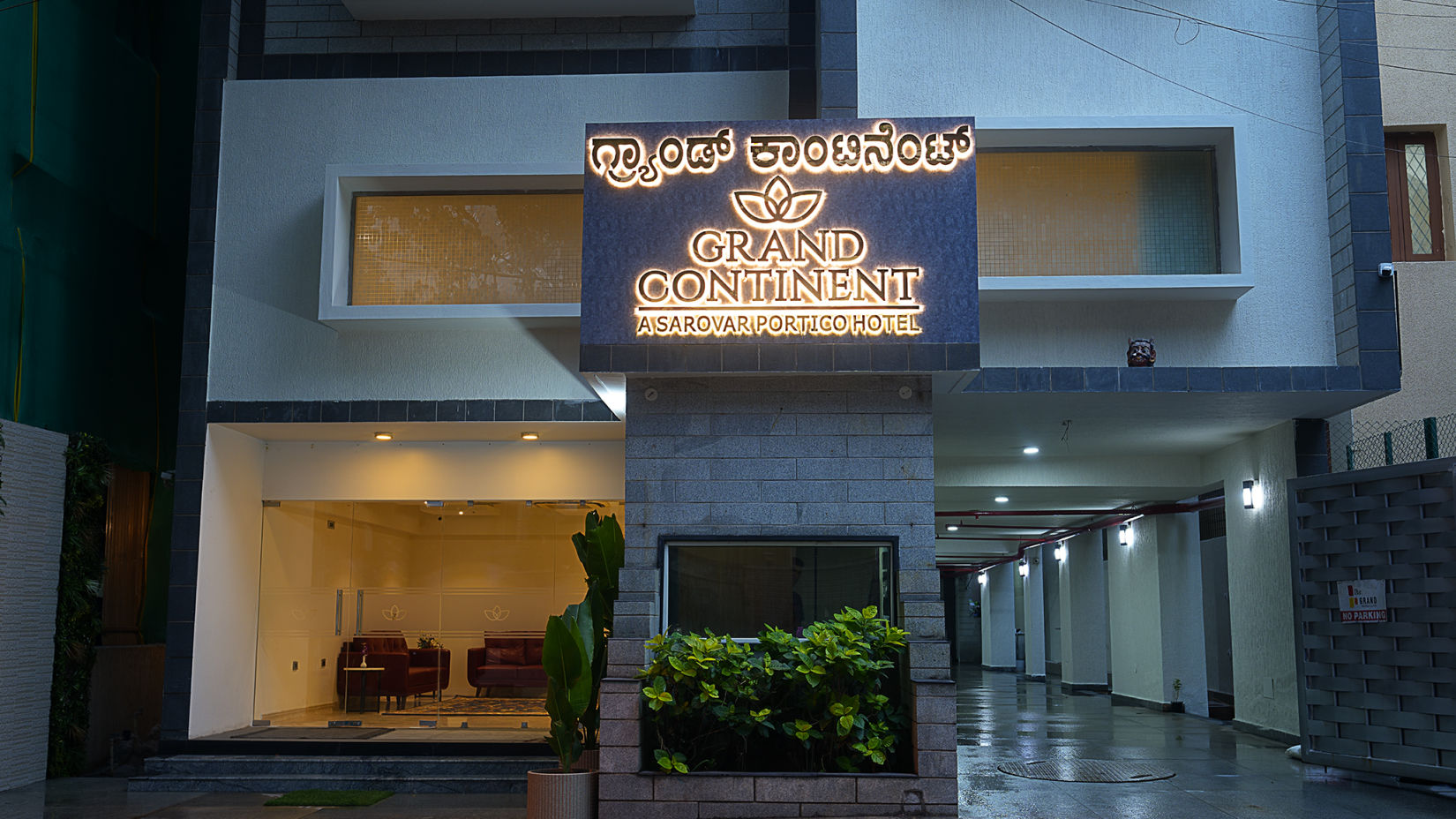 A facade view of our hotel with the name illuminated by bright lights - Grand Continent, Malleshwaram