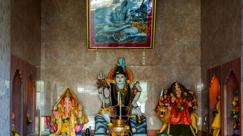 idots of hindu deities shiva, parthavthi and ganesha kept in a temple