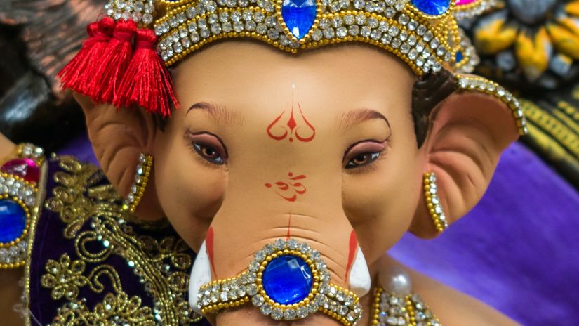 idol of lord ganesha with a red and blue crown