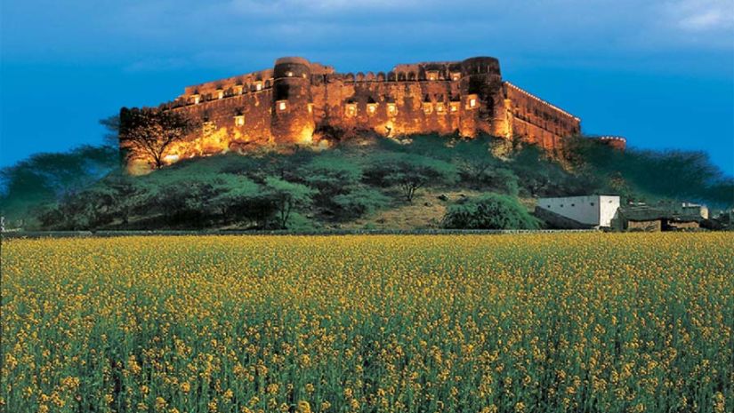 The facade of Hill Fort Kesroli Kesroli with grass at the forefront