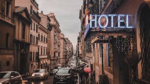 a street with a hotel at the front and cars travelling