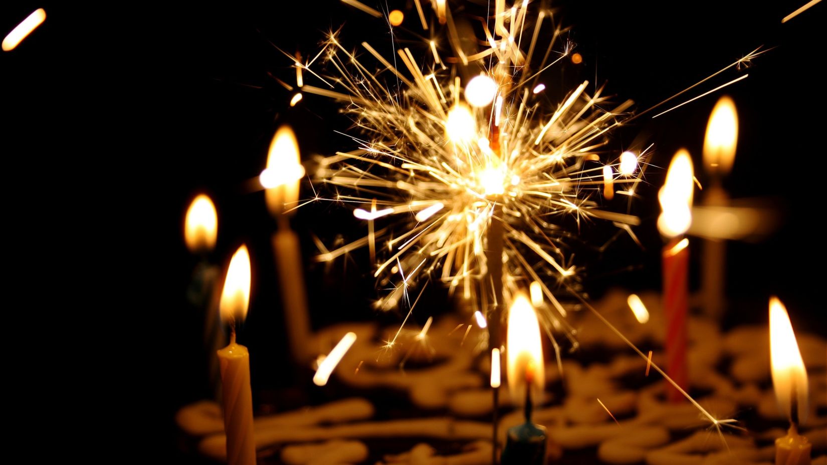 a sparkler with candles in the background