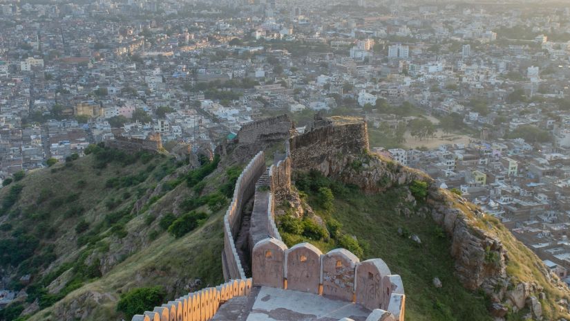 a bird's eye view of the Alwar Fort from above with greenery surrounding it