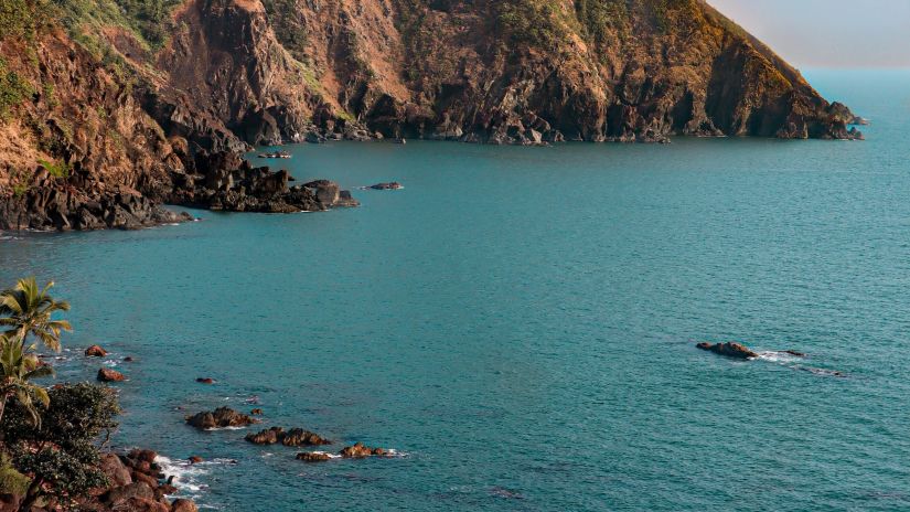 Hill-top view of Cabo de Rama Beach featuring blue ocean water  under clear blue sky